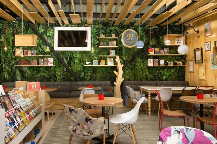 café med bokhandel väggväxter tak träskivor eames stol
