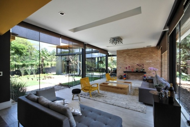 eklektisk-vardagsrum-design-tegel-vägg-stolar-design-gul