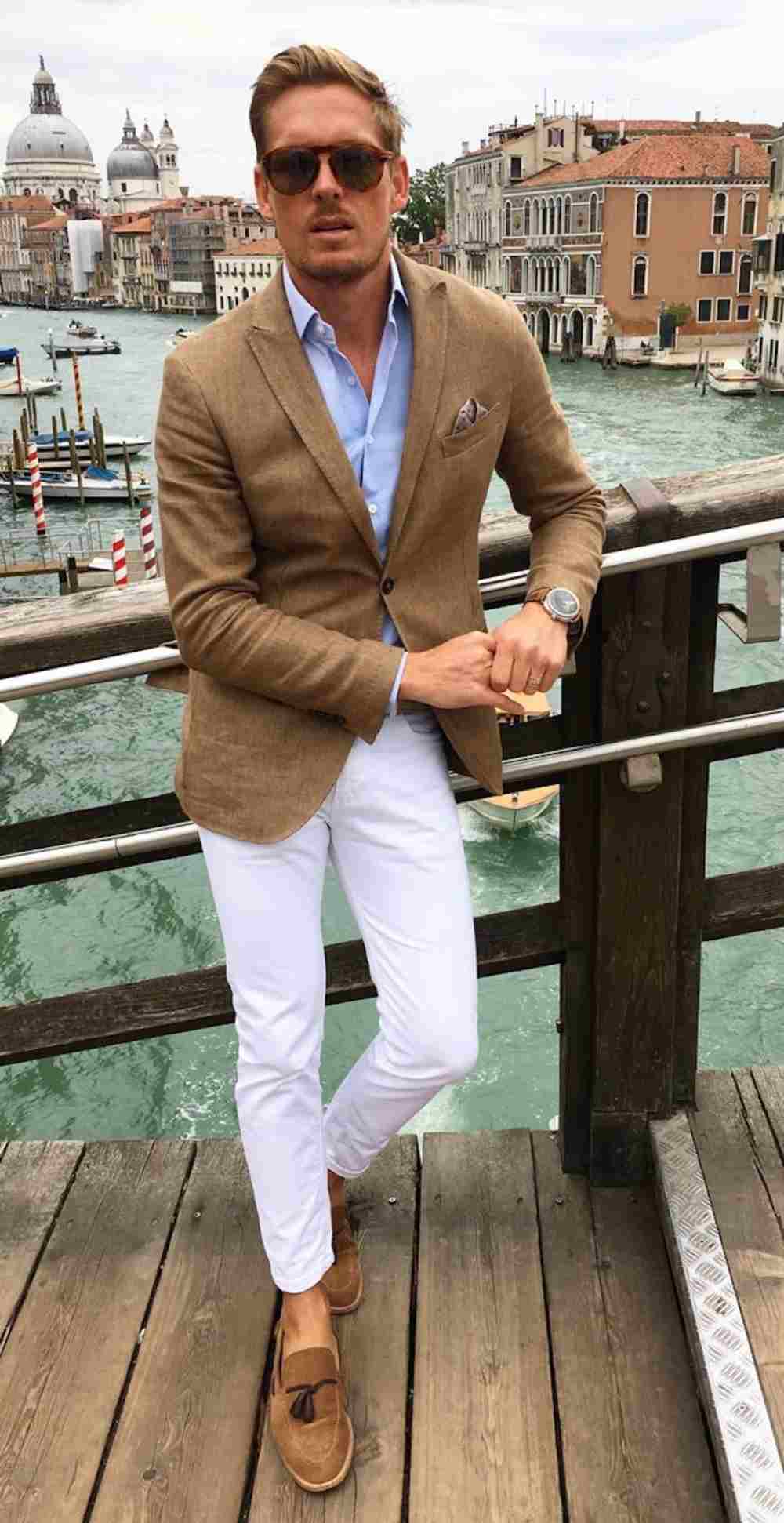 modern outfit man med brun blazer, ljusblå skjorta och vita chino byxor kombinerar män
