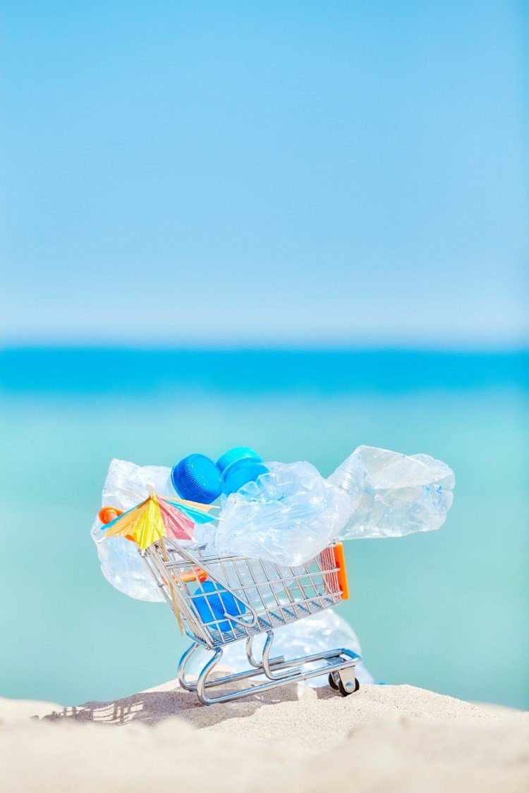 Symboliserar kundvagn med plastflaskor som skräp i havet