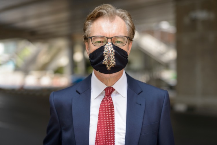 Resande affärsman bär ansiktsmask skyddsmask på grund av corona -resa