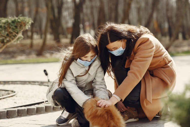 mor och dotter som klappar djuret under solen vid corona samlar på sig vitamin d