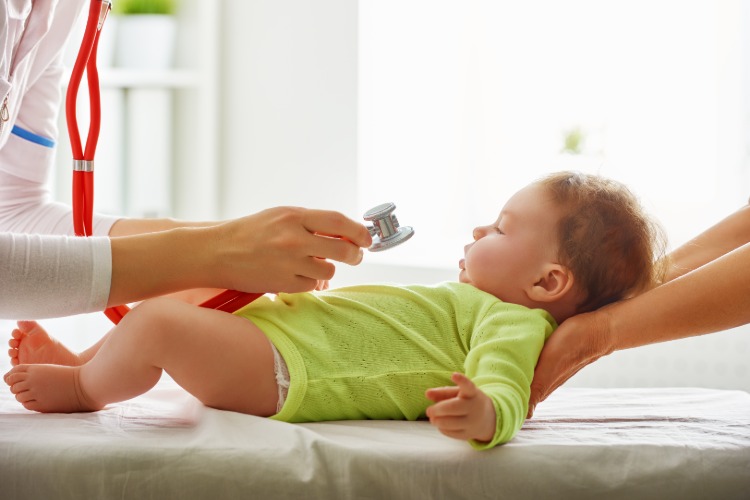 läkare undersöker symptom på coronavirus hos spädbarn på sjukhus