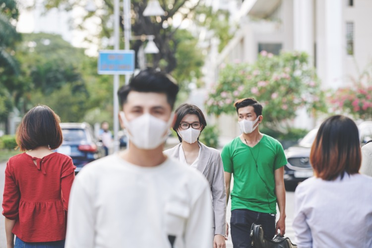 flera invånare i wuhan city i Kina med skyddsmasker som går på gatorna