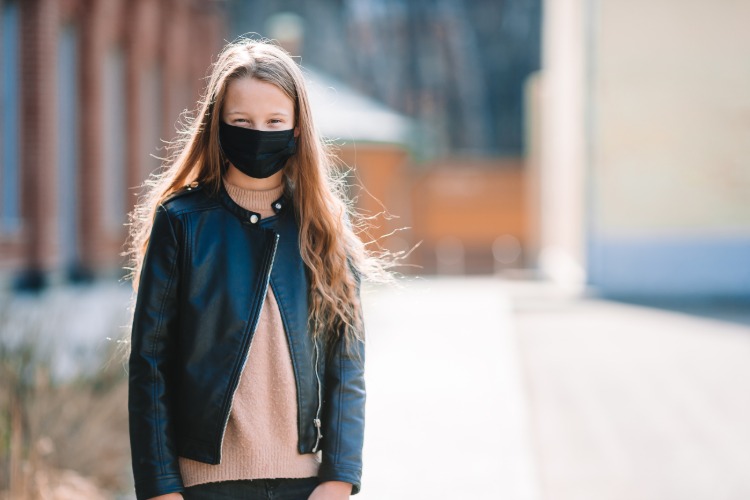 ung flicka bär svart skyddsmask på grund av coronavirusets spridning