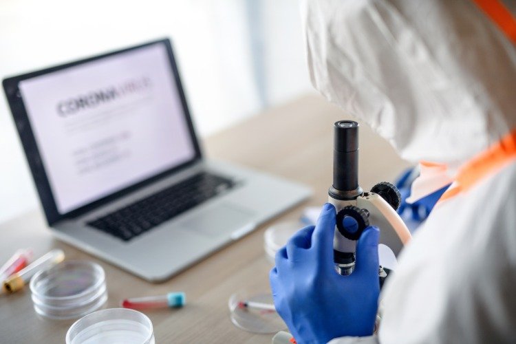 läkare i skyddskläder analyserar covid-19 coronavirus blodprov