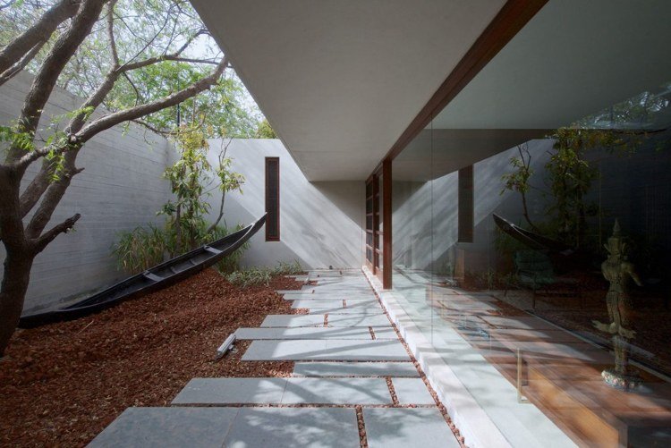 innergård-betong-vägg-ramlös-fönster-betong-gångväg-mulch