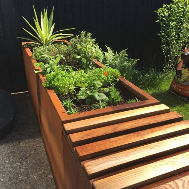 Bygg en upphöjd säng i cortenstål med en bänk i trädgården