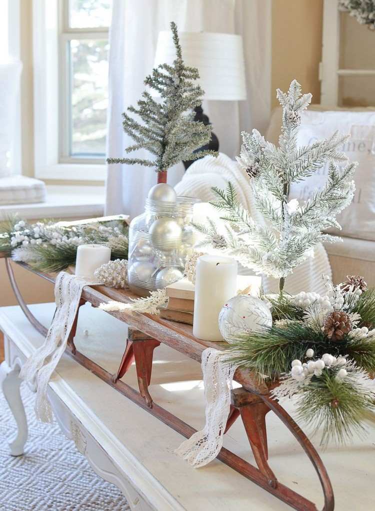 Dekorera soffbordet till jul med en pulka och LED -ljus och grangrenar
