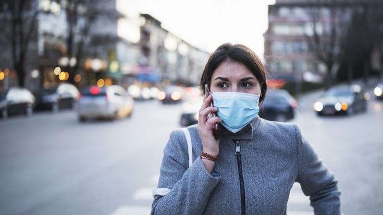 orolig kvinna på gatan med skyddsmask mot covid -virus
