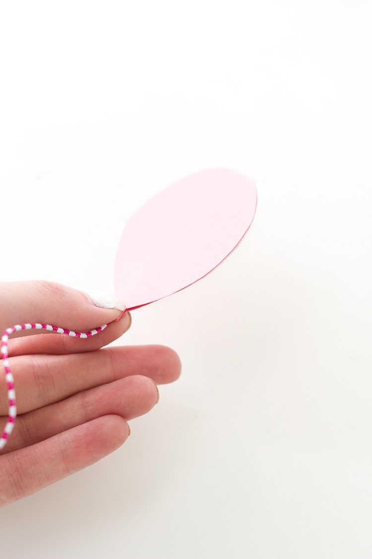 Gör en ballong av rosa papper och fäst den på ett gem