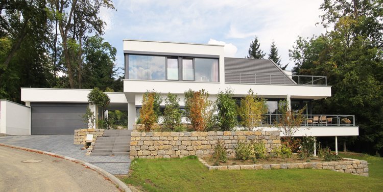tak-former-sadel-tak-hus-modern-fram trädgård-stödmur-ovanlig-tak-form-bostadshus