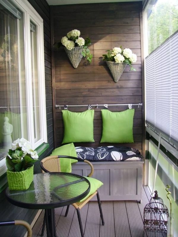 balkong smal yta-dekoration med växter gröna kuddar bänk