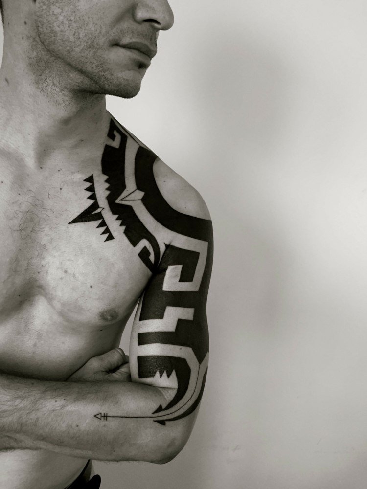 blackwork tatuering tribal män axel överarm pil traditionella symboler