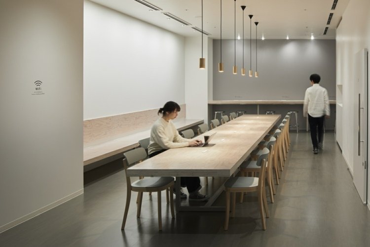 Minimalistisk matplats i kapselhotellet i Japan med matbord och hängande lampor