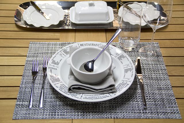 porslin vita bokstäver mönster grå bordsmatta servett