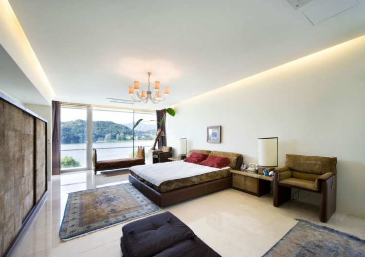 Balkongräcke-glas-sovrum-säng-fåtölj-lampa-matta-fönster front-garderob-bild