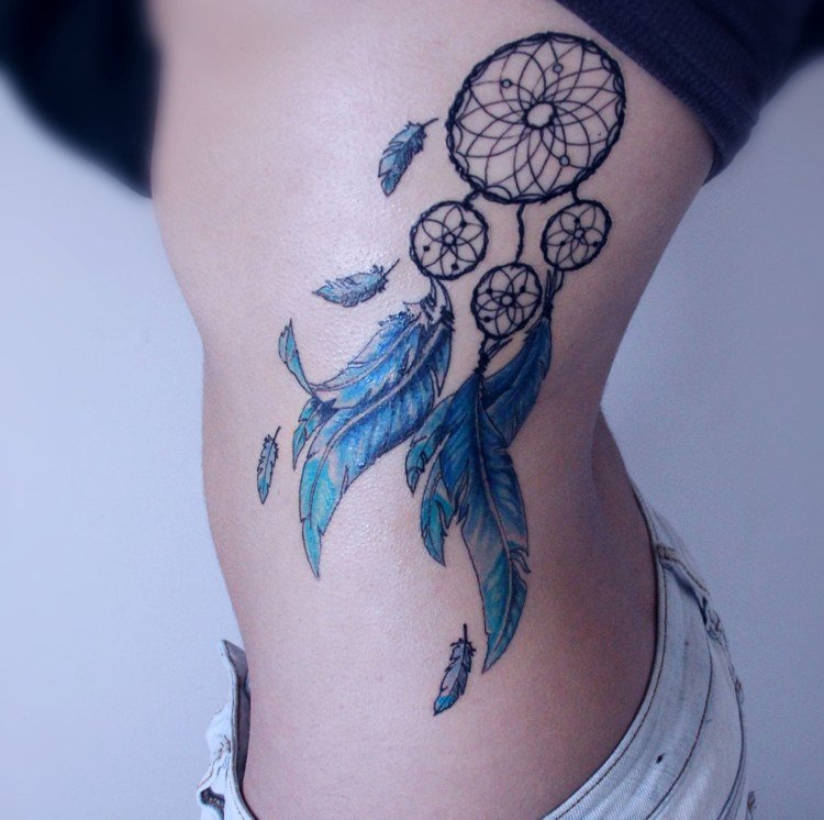 Drömfångare tatuering revben kvinna blå fjädrar