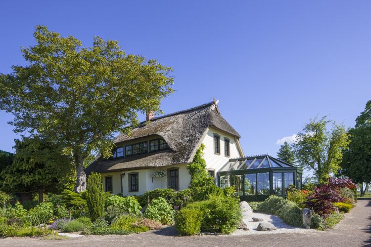 Enfamiljshus med halmtak och vinterträdgård