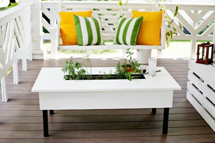 Dekoration till terrassen vit-trädgårdsbord-kruka-växter-örter-hängande stol-gula kuddar