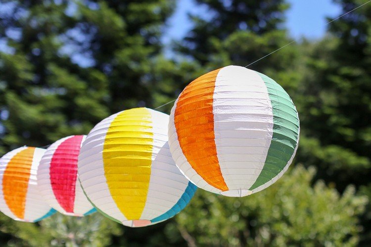 Gör sommarfestdekorationer själv, häng upp färgglada strandbollar från papperslyktor