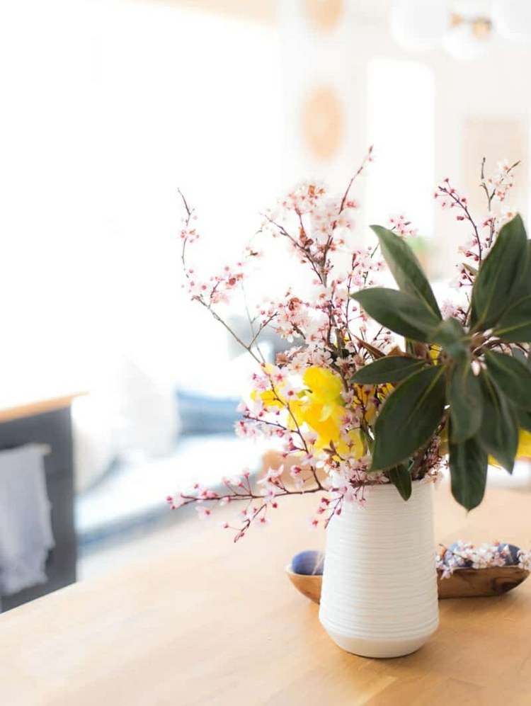 Ganska liten bukett gjord av rosa grenar, gula blommor och gröna blad
