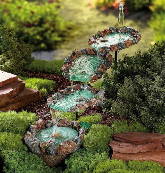 liten fontän med naturstenar i trädgården