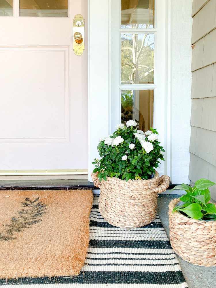 Miniroskorgar, matta och dörrmatta som dekoration för husets entré på sommaren