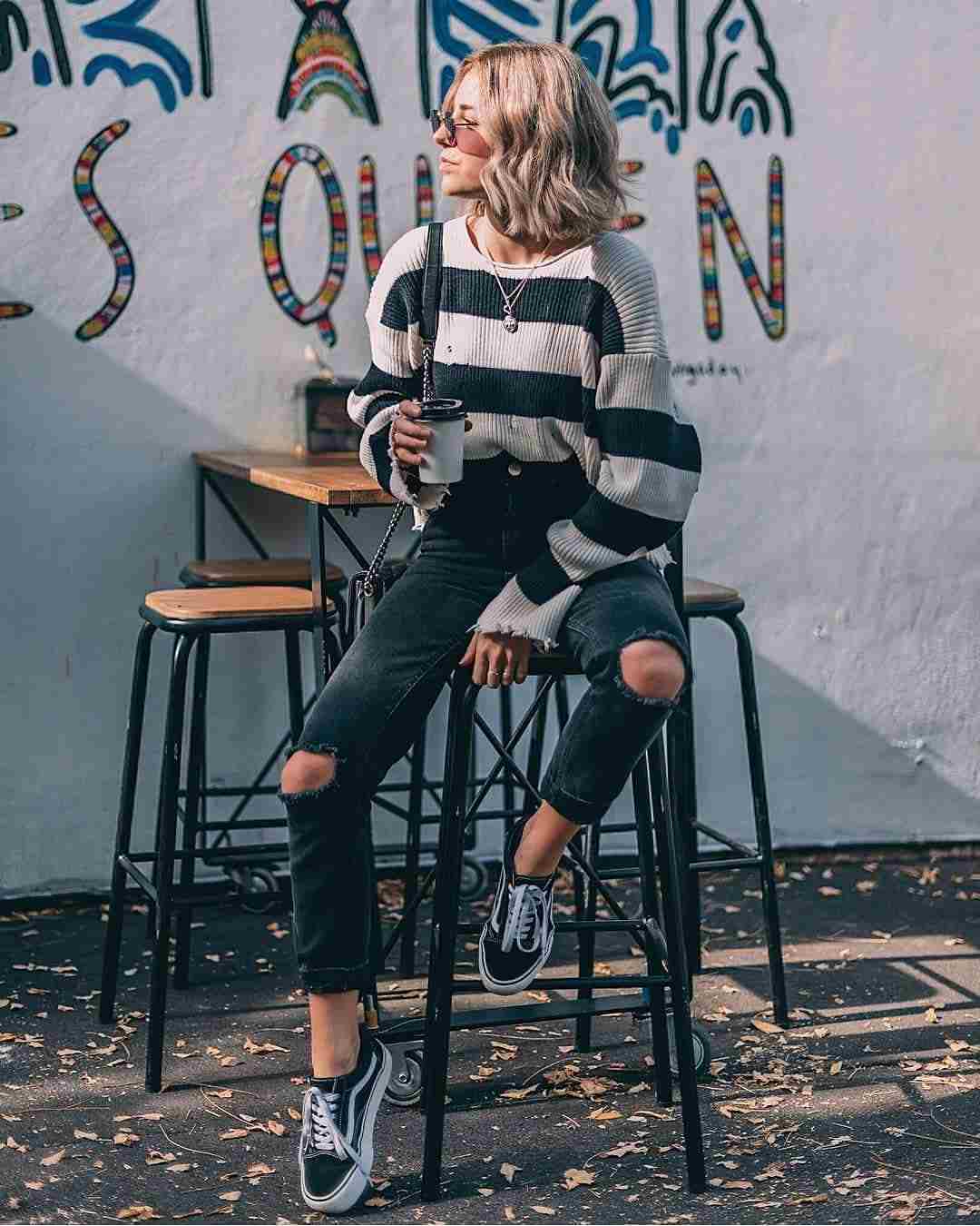 Mom jeans kombinerar svart stickad tröja oversize sneakers mörkblont hår modetrender 2019