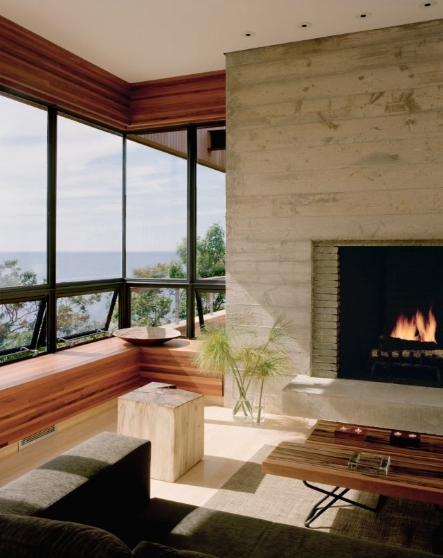 öppen spis vardagsrum bild fönster trä bänk pall exponerad betong