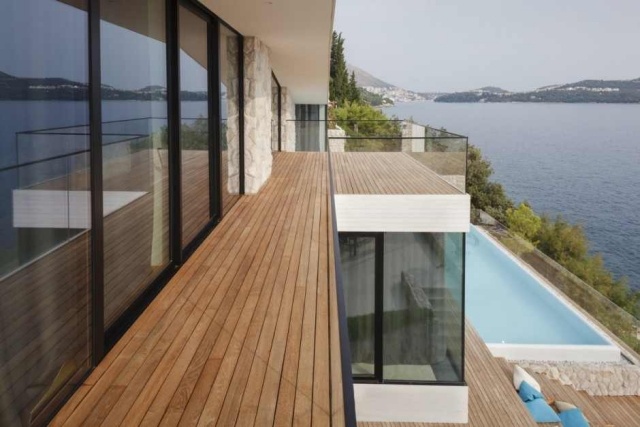 Modernt husglasad fasad trädäck balkong havsutsikt