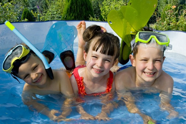 Barn som paddlar pool sommaridéer som kyler av trädgården