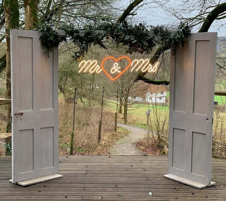 Original båge för bröllopet med dörrar och Mr Mrs. Neon bokstäver i vintage stil