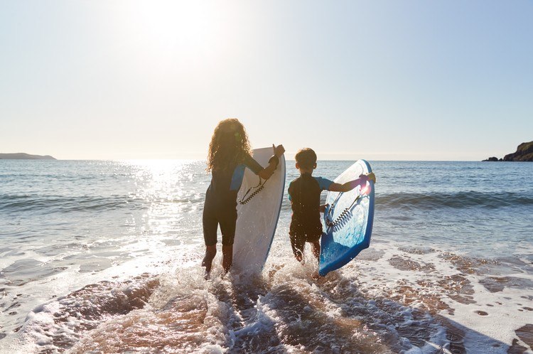 Sommarsport för barn som surfar i havet