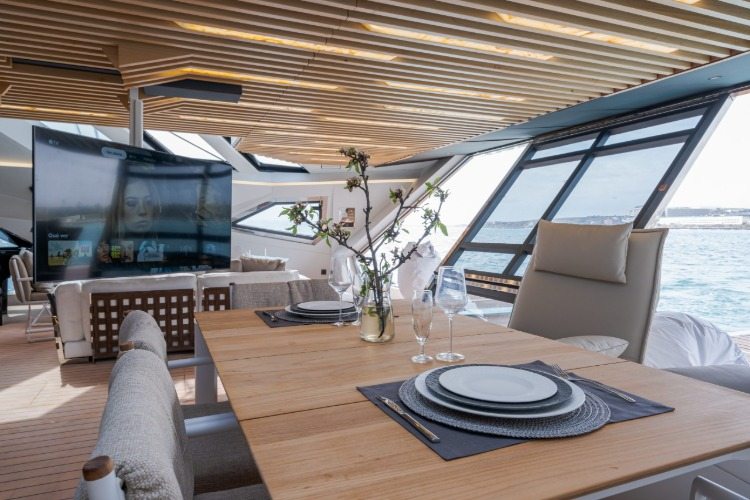 vardagsrum med stor tv och matbord i trimaran yacht hanstaiger x1