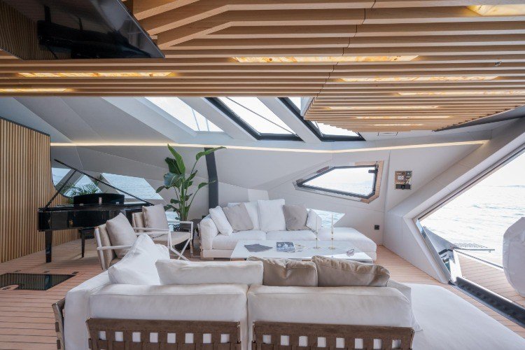 extra vardagsrum med en kunglig och vit soffa på brädan på en trimaranbåt med trätak