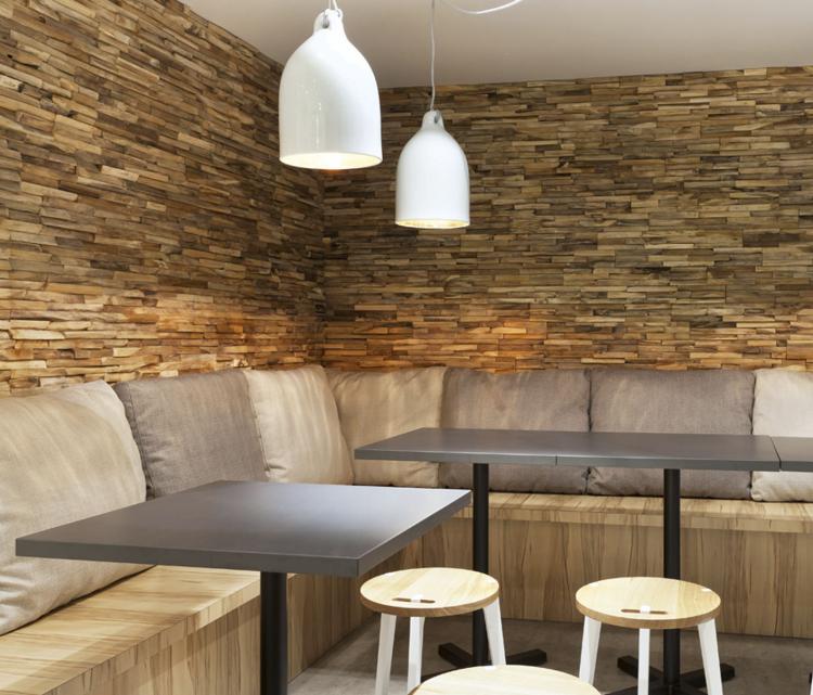 trä-väggbeklädnad-interiör-modern-hörn-sittplatser-hängande-lampor-kuddar-trä-pall