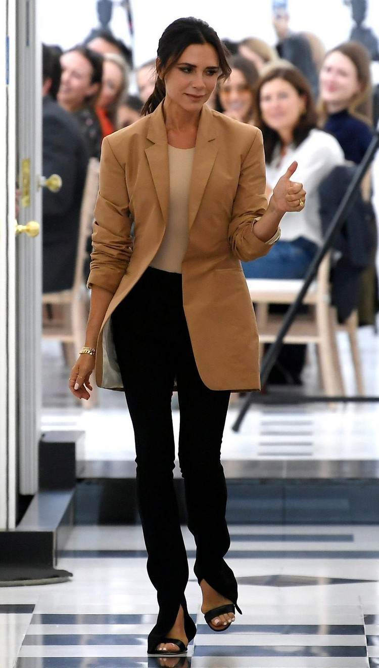 Victoria Beckham med svarta delade byxor och en brun oversize blazer