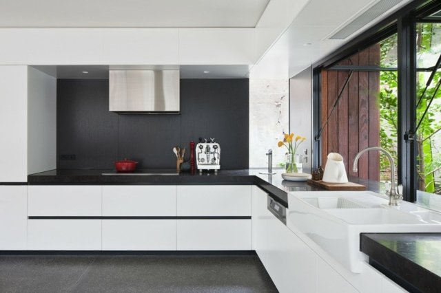 Handtagslösa köksskåp, minimalistiskt utseende, svart bakvägg