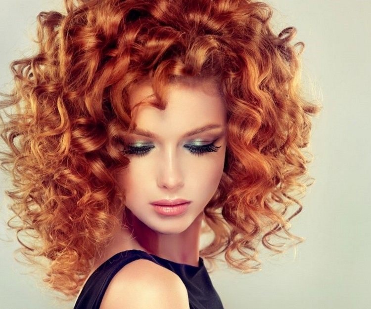Kopparorange hårfärg med en ljus nyans av naturliga lockar av medellångt hår
