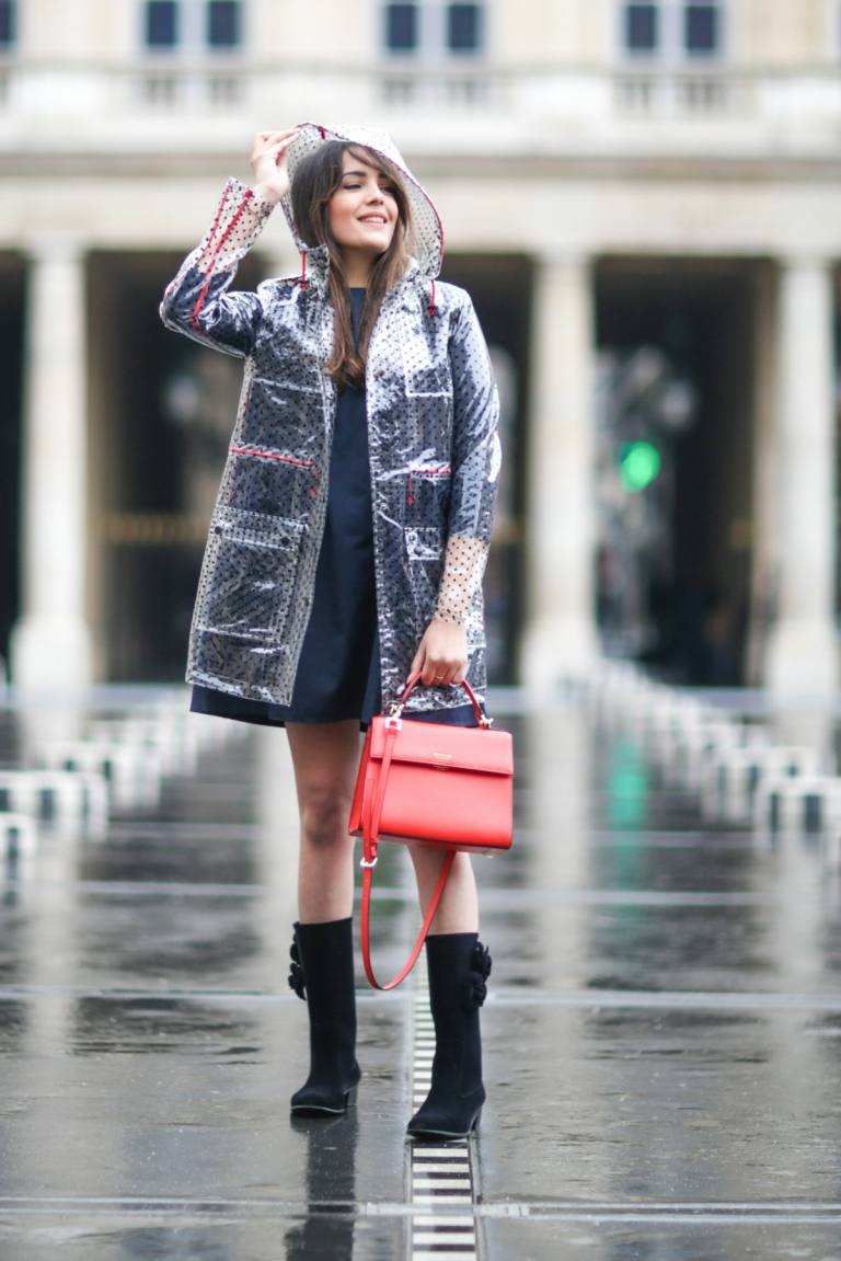 En genomskinlig regnrock ger en glimt av damens outfit under