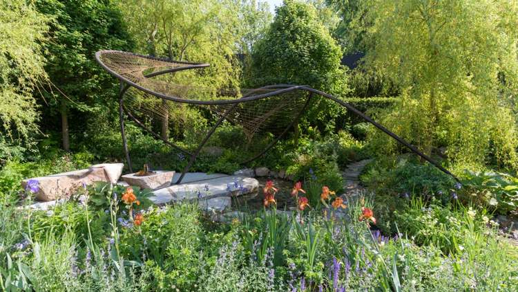 Engelsk trädgård natursten damm iriser metall skulptur