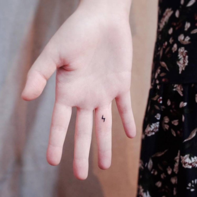 Miniatyr tatuering finger inuti blixt symbol