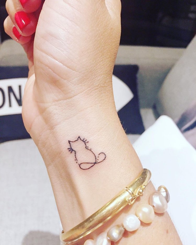 liten tatuering katt handleden kvinna oändlighet symbol