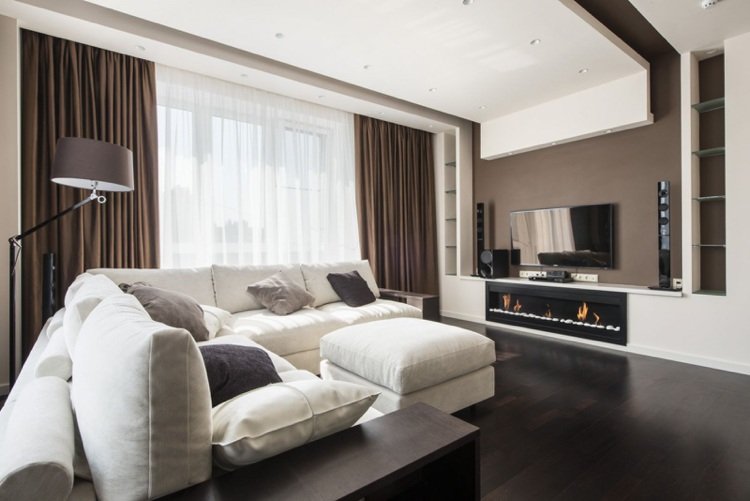 Väggfärg brun vardagsrum vit soffa mörkt trägolv undertak
