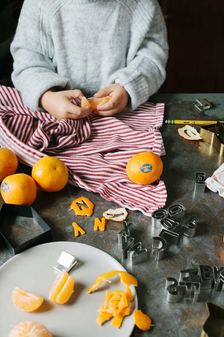julgarland diy -projekt med barn apelsinskal som dansar ut bokstäver figurer
