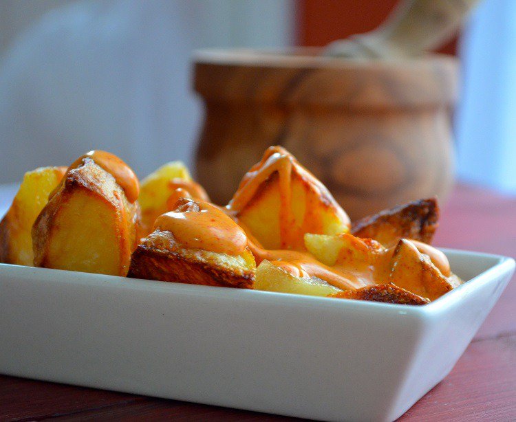 förbereder patates bravas tapasrecept med potatis, varm tomatsås