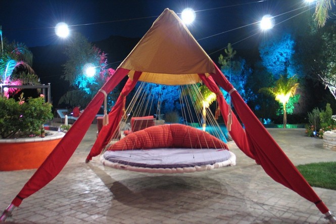 vacker hängande säng med röda gardiner