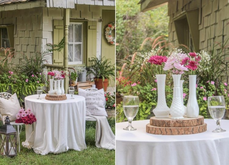 Vintage trädgårdsborddekoration med vita vaser, träskivor och rosa och rosa blommor