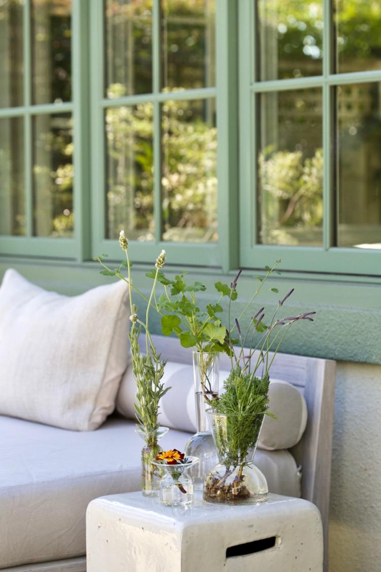 Dekorera sidobordet på terrassen med pelargoner, lavendel och ringblomma i ett glas